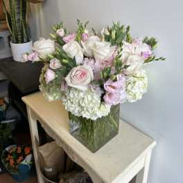 Bouquet of white and pale pink roses in a clear glass vase