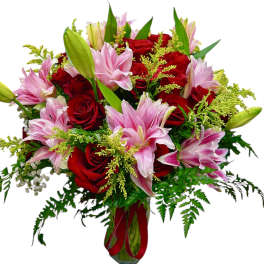 Bouquet of red roses and pink lilies in a glass vase