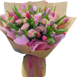 Bouquet of pink tulips and carnations wrapped in brown paper
