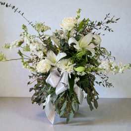 White floral arrangement with roses and lilies in a vase