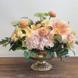Peach and blush floral arrangement in a gold pedestal vase