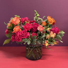 Bouquet of pink and orange flowers in a glass vase