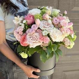 Large pastel bouquet of roses and mixed blooms in a gray hatbox