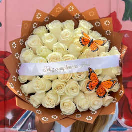 Bouquet of cream roses wrapped in brown paper with butterfly decorations