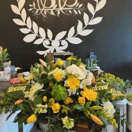 Yellow and white funeral spray with roses, lilies, and orchids