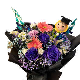 Bouquet of purple roses and pink gerbera daisies with a graduation topper