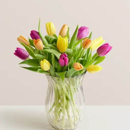 Colorful tulips arranged in a clear glass vase
