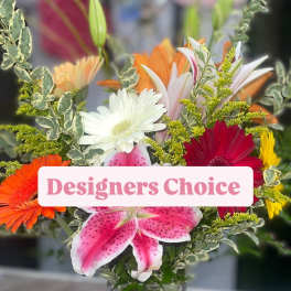 Mixed bouquet of lilies, gerbera daisies, and a pink lily in a glass vase