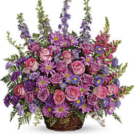 Basket arrangement of pink roses and purple flowers