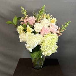 Pink and white roses with hydrangeas in a glass vase