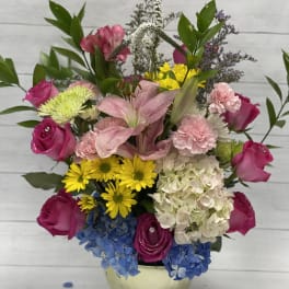 Mixed bouquet with pink roses, lilies, hydrangea, and yellow daisies in a vase
