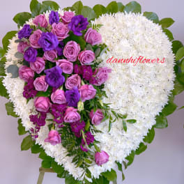 Heart-shaped floral wreath with pink and purple roses on white blooms