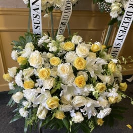 White and yellow funeral wreaths with memorial ribbons