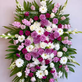 Large standing spray of pink, white, and purple flowers on an easel