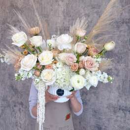 Large bouquet of white and blush roses in a white vase