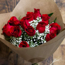 Bouquet of red roses with white baby's breath wrapped in brown paper