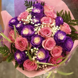 Bouquet of pink and purple roses wrapped in pink paper