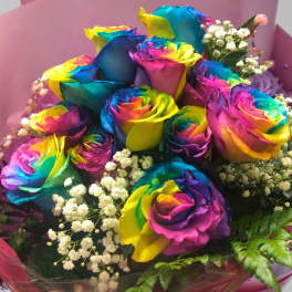 Bouquet of rainbow-colored roses with baby's breath in pink wrapping