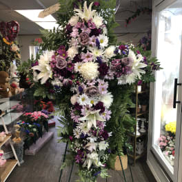 Tall standing floral spray with white lilies and purple flowers