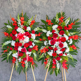 Two large standing floral sprays with red, white, and orange flowers