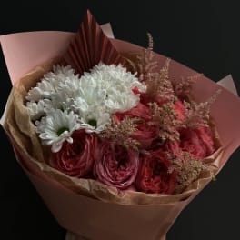 Bouquet of pink roses and white daisies wrapped in pink paper