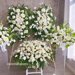 White floral funeral sprays and a casket spray with lilies and roses