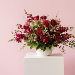Red rose bouquet in a white bowl vase