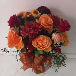 Bouquet of orange and red flowers with a plaid ribbon