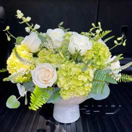 White roses and green hydrangeas in a white vase