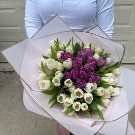 Bouquet of white and purple tulips wrapped in pale pink paper