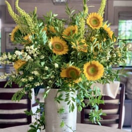 Tall vase arrangement with sunflowers and airy greenery