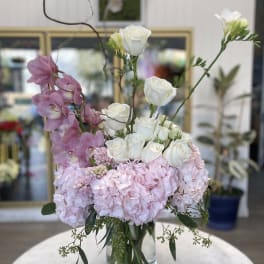 Pink and white floral arrangement in a clear glass vase