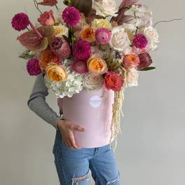 Large bouquet of pink, white, and peach flowers in a pink box