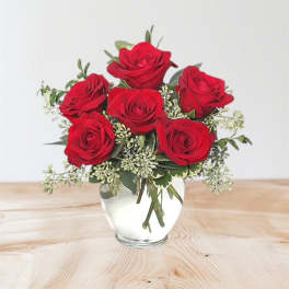 Red roses arranged in a clear glass vase