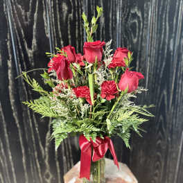 Red roses and carnations in a glass vase with a red ribbon