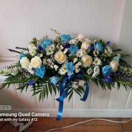 Blue and white rose arrangement with daisies and ribbon