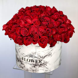 Large bouquet of red roses in a marble-patterned box