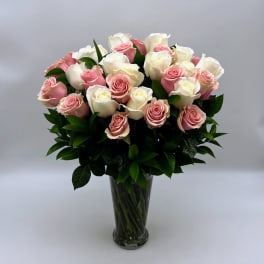 Pink and white roses arranged in a clear glass vase
