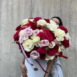 Large bouquet of red, white, and pale pink roses in a white hat box