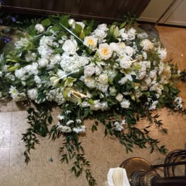 Large white floral spray with roses and lilies on the floor