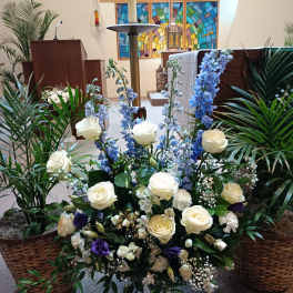 Large white and blue floral arrangement in a white vase