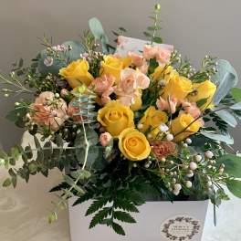 Yellow roses and peach carnations in a white gift box