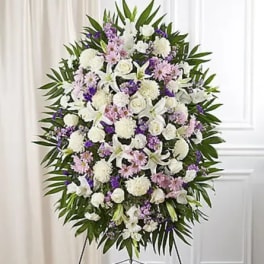 Large standing spray of white, pink, and purple flowers on an easel