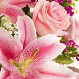 Pink lilies and a pale pink rose with purple filler flowers