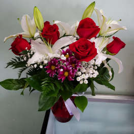 Bouquet of red roses and white lilies in a red vase