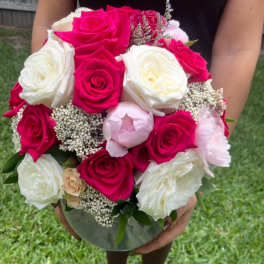 Bouquet of hot pink and white roses in a clear vase