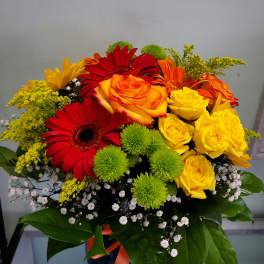 Bouquet of red, orange, and yellow flowers in a dark vase