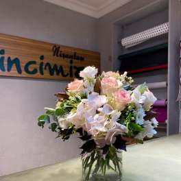 Bouquet of pale pink and white roses in a clear glass vase