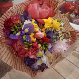 Colorful bouquet of mixed flowers wrapped in striped paper