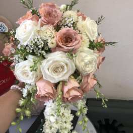 Bouquet of blush and white roses with small white filler flowers
